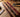 English bridle, harness, and latigo leather straps compared side by side on a saddle shop workbench