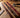 English bridle, harness, and latigo leather straps compared side by side on a saddle shop workbench