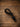 Black braided nylon rope tie down keeper with hand-tied knot, coiled on barn wood