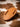 Light leather fixed blade knife sheath angled to show thickness on a cowhide background