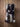 Top view of black and white cowhide boot bag showing two zippered boot compartments and strap
