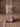 Red and white speckled hair-on-hide cowhide boot bag standing on weathered barnwood