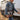Woman in a denim jacket carrying the hair on hide cowhide portfolio #4 beside a horse trailer
