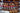 Detail of pink, turquoise, royal blue, white and brown chrome tan lacing woven in chevron pattern through burgundy latigo core