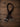 Pair of dark oil latigo rein extensions with stainless steel cart buckles and scissor snaps on wood background