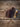 Dark brown leather pocket knife sheath on barn wood beside a Case Trapper style folding knife