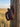 Leather pocket knife sheath hanging on a weathered fence post at golden hour
