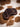 Angled dark brown leather pocket knife sheath showing its thickness on a cowhide background
