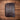 Back of the tooled leather portfolio showing the solid dark brown oil-tanned leather panel, stitched border, and zipper with leather pull