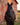 Black horse saddled in front of a weathered red barn wearing the pink buckstitch breast collar and a plain dark oil headstall