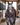 Dapple gray horse in a barn aisle wearing a western saddle and the pink buckstitch breast collar, front view