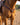 Pink buckstitch breast collar on a sorrel horse in a western saddle, chest view in an outdoor arena showing the center concho and cinch strap