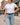 Pink Heritage Buckstitch Belt styled casually with white tee and light jeans on a western small-town street