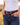 Woman wearing the purple buckstitch leather belt with silver western buckle and jeans on a ranch at golden hour