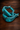 Close-up of 2 inch distressed turquoise rosewood stirrups tipped on their side, highlighting leather-laced tread detail